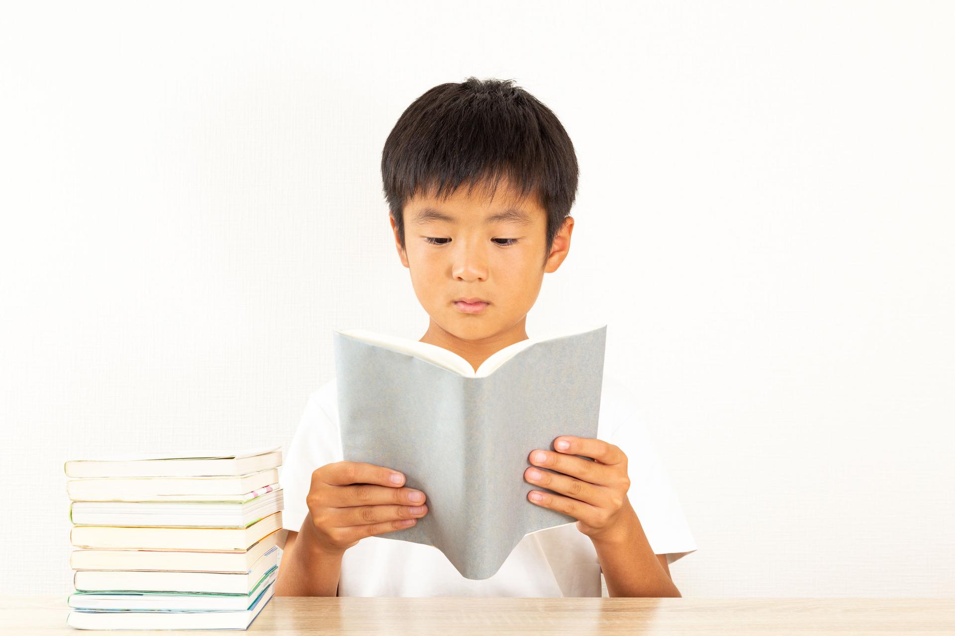A boy reading in his room.